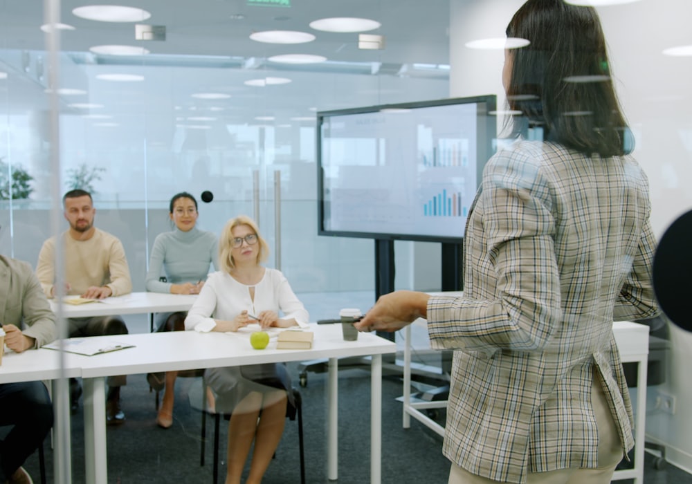 Facilitadora dirigiendo un taller para un grupo en una sala de reuniones